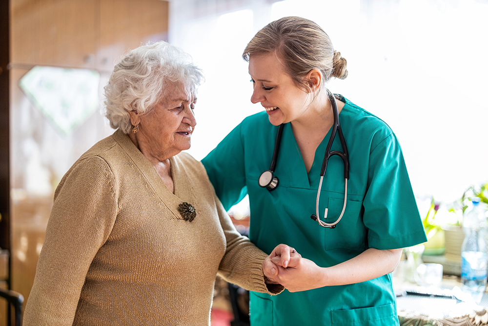 smiling doctor holding elderly woman's hand