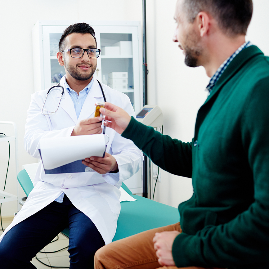 male doctor with male patient passing medication